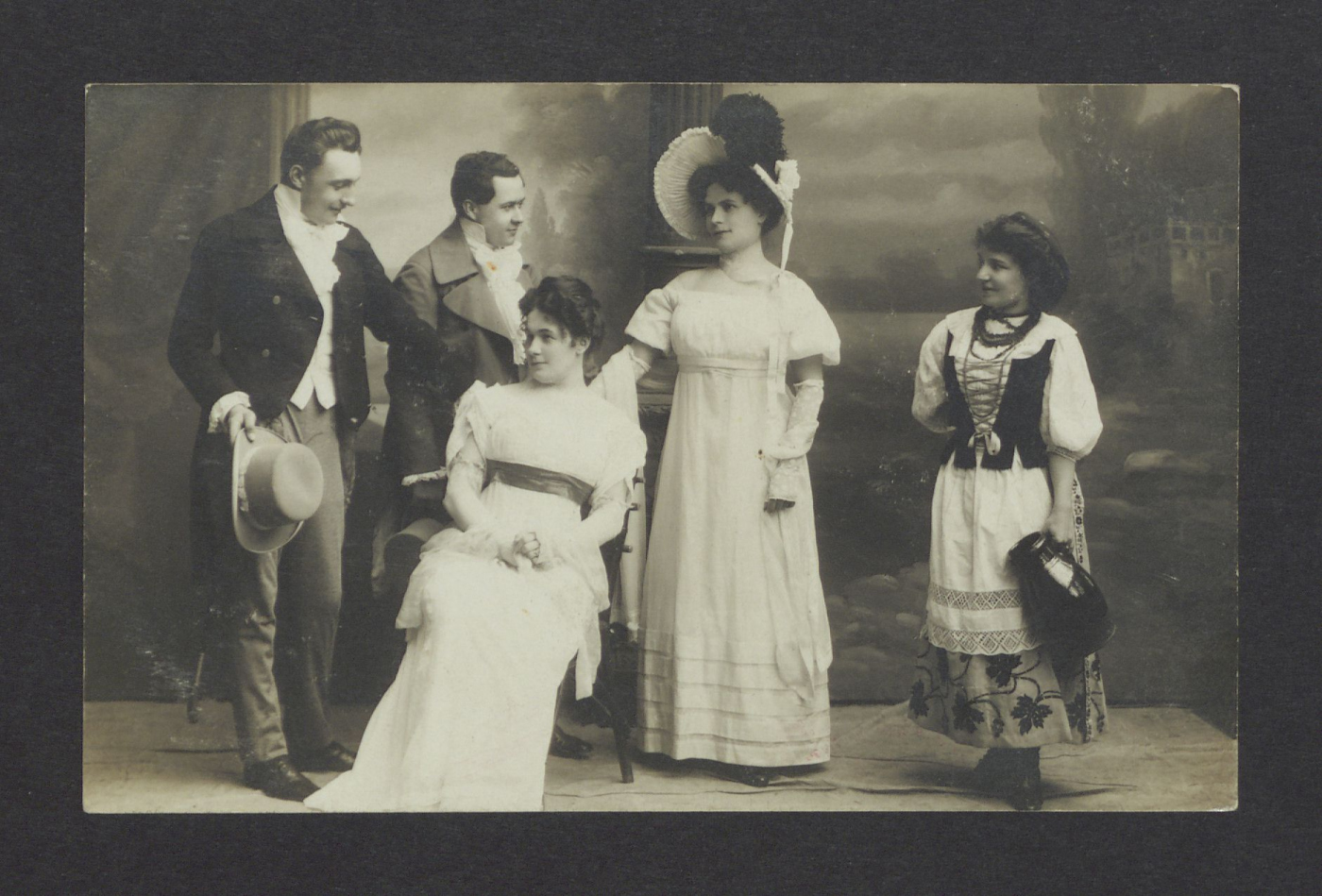 Dwóch mężczyzn i trzy kobiety odgrywają scenę teatralną. 