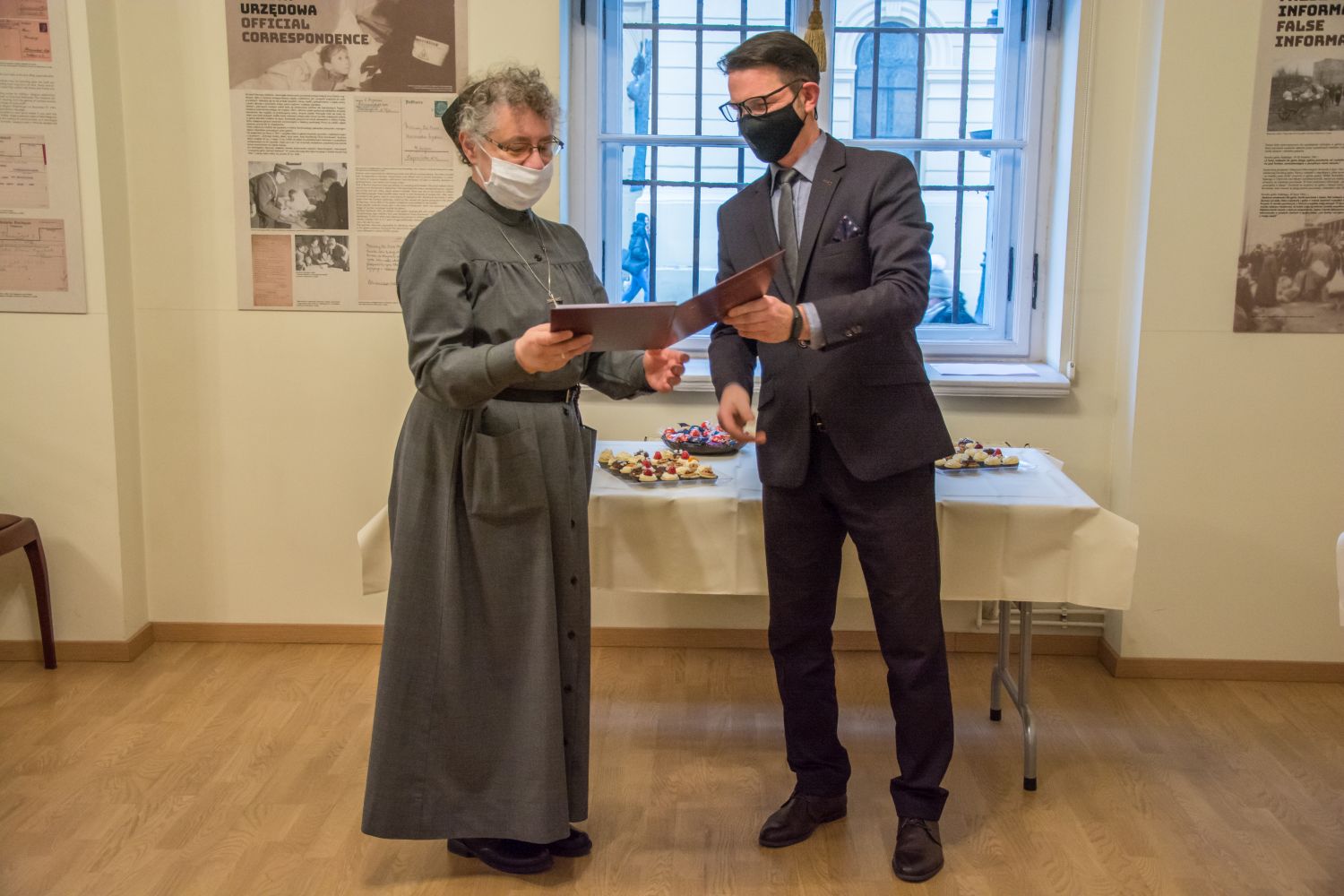 Dyrektor wręcza dyplom darczyni - zakonnicy w habicie.