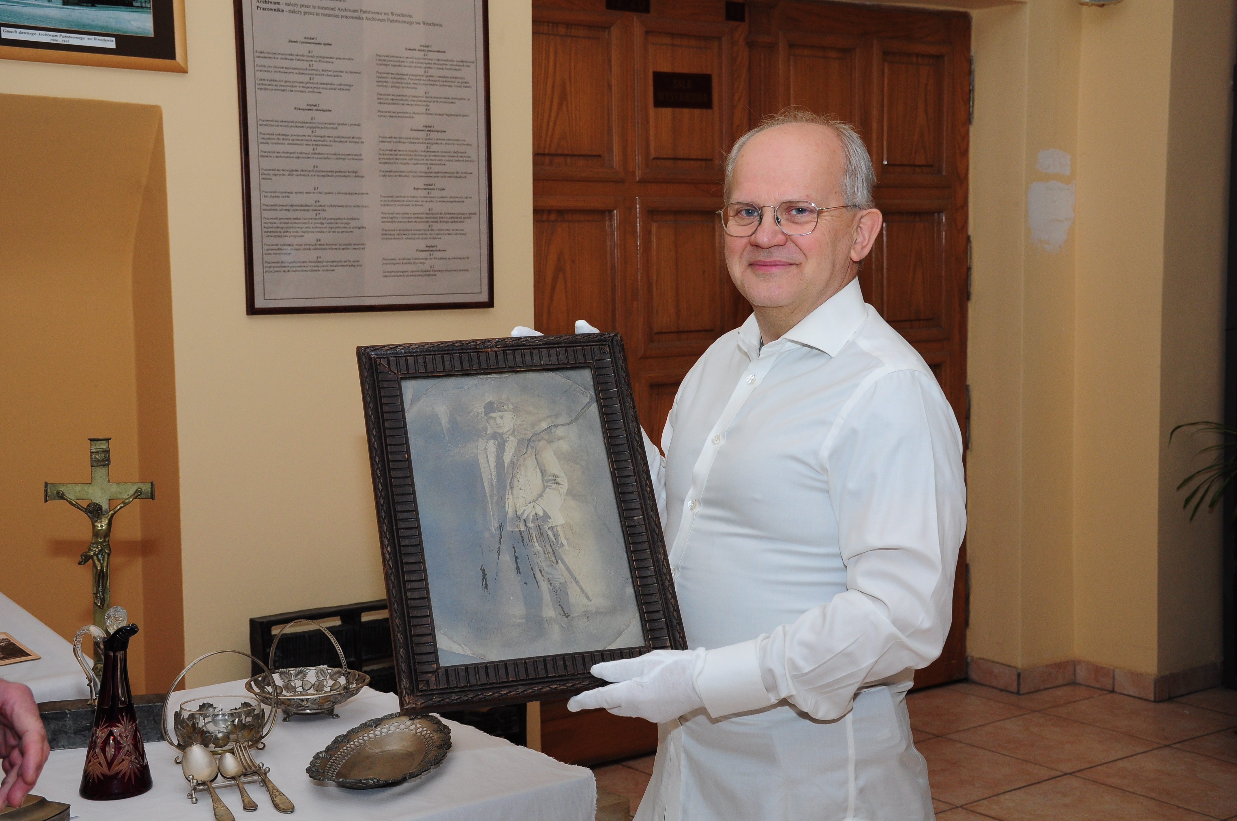 Krzysztof Michałowski trzyma w ręku portret swojego dziadka.